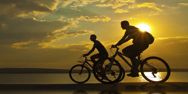 couple cycling in the sunset 