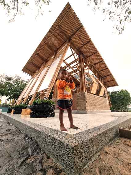 A child standing in front of the school building A child standing in front of the school building