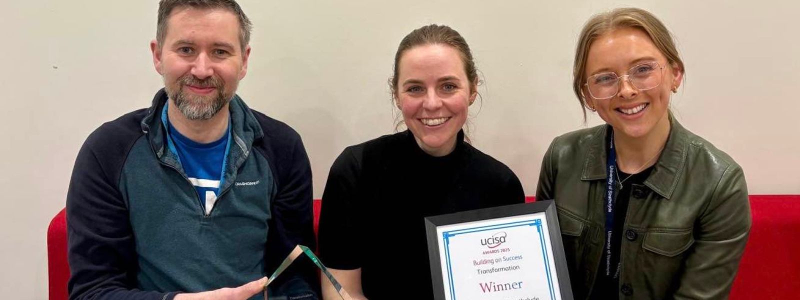 Three team members holding UCISA award